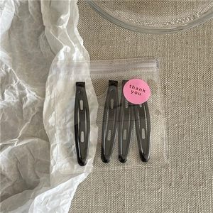 Close-up of 4 black water-drop hair clips in a transparent bag with a pink thank you sticker