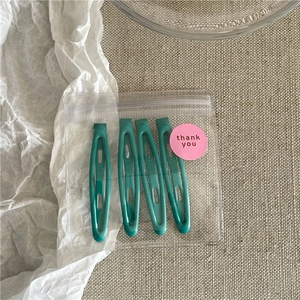 Detail of four teal marble resin hair clips in clear packaging with thank you sticker