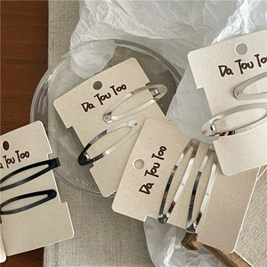 Barrettes à cheveux minimalistes en métal noir et argent sur support cartonné