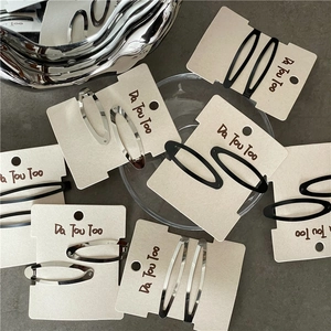 Barrettes à cheveux ovales en métal argenté et noir sur carte de présentation