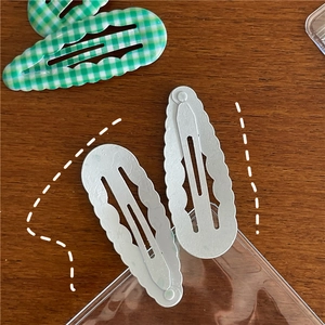 Détail de barrettes BB à carreaux et unies, forme goutte d'eau avec bords ondulés en métal