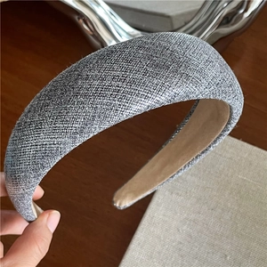 Close-up of a thick grey fabric headband showing fine woven texture and soft inner lining