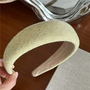 Detail of light green sponge headband showing textured fabric and beige suede lining