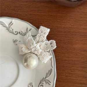 French retro lace bow hair clip with faux pearl on a vintage porcelain plate decoration