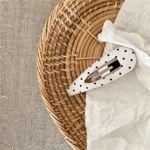 Detailed view of vintage black and white polka dot fabric drop BB clip with metal base
