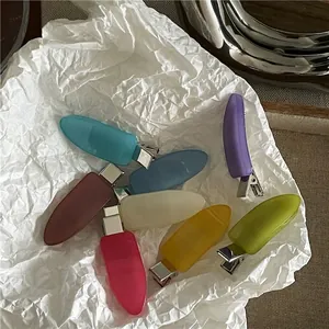 Set of colorful matte drop-shaped hair clips with metal duckbill spring clips on paper