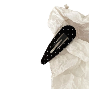 Minimalist black and white polka dot fabric teardrop hair clip on white background