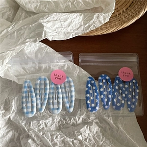 Detail van lichtblauwe geruite en donkerblauwe polkadots haarspeldjes in cadeauverpakking