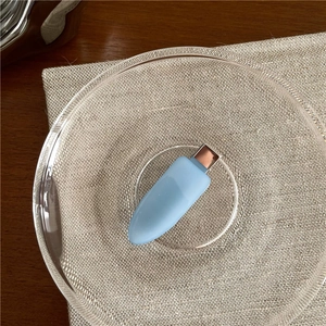 Detail of light blue matte hair clip with rose gold metal clasp on a glass plate