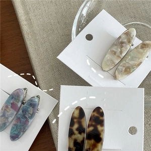 Vue macro détaillée de trois barrettes en acétate aux motifs nacrés, floraux et écaille de tortue
