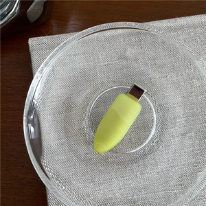 Close-up of a pale green capsule-shaped USB drive on a textured background