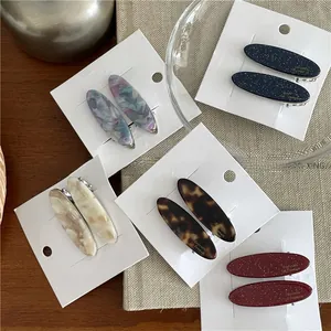 Vue détaillée de barrettes ovales en acétate aux motifs marbrés et écaille de tortue élégants
