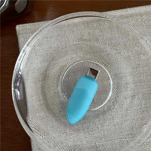 Detail of light blue jelly texture hair clip on a glass tray with a beige linen background