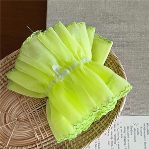 Detailed texture of fluo green organza mesh scrunchie in a rustic bamboo basket