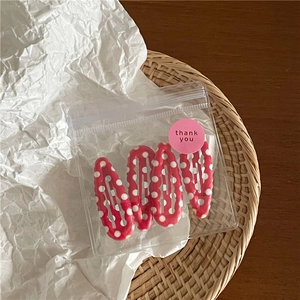 Detailset van 4 rode haarclips met stippen in druppelvorm in cadeauverpakking met zegelsticker