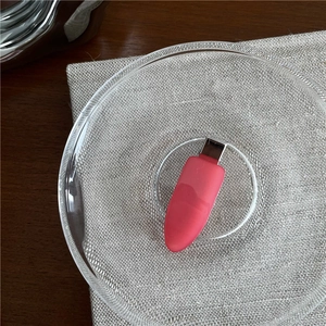 Pink capsule mini portable power bank with metal plug connector on grey linen