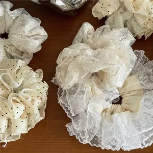 Set de chouchous élégants en dentelle florale et organza sur fond de bois vintage