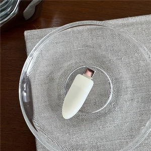 Close-up of a sleek white USB-C adapter on a textured glass plate with modern aesthetics