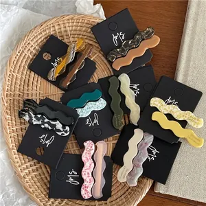 Barrettes à cheveux ondulées en acétate aux textures marbrées et couleurs douces sur plateau