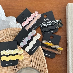 Détails de barrettes à cheveux ondulées en acétate avec motifs fleuris et marbrés