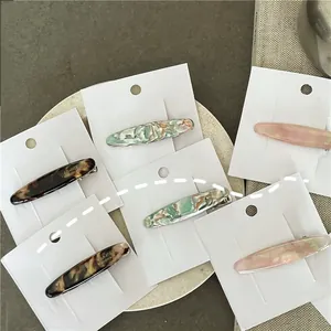 Close-up of handmade acetate hair clips with marble texture and tortoise patterns