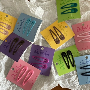 Detail of colorful drip glaze cream-colored teardrop hair clips set on paper cards