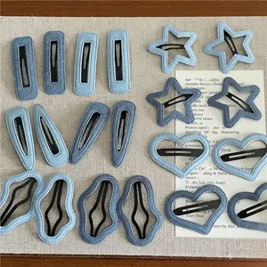Denim fabric hair clips in heart star and teardrop shapes set on woven mat