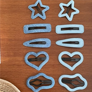 Flat lay of denim fabric hair clips in star, heart, and rectangle shapes on wood
