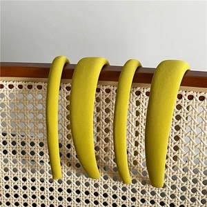 Detailed view of four yellow twill texture padded headbands on a wooden wicker chair