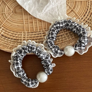 Detail of checkered scrunchies with white lace trim and large faux pearl accents