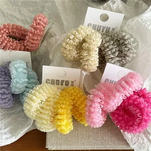 Detail view of mesh lace scrunchies in multiple pastel colors with branded paper cards