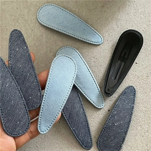 Close-up of denim fabric water-drop BB clips with detailed stitching and metal snap back