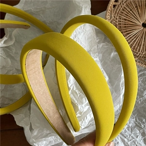 Detail shot of bright yellow twill fabric headbands with thick sponge padding on white paper