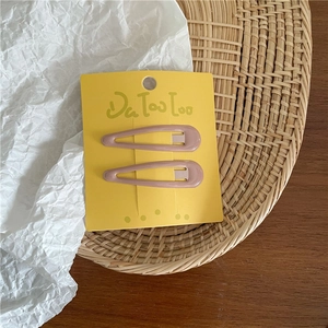 Detail view of two lotus pink matte waterdrop BB hair clips on yellow card packaging