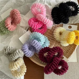 Flat lay detail of colorful lace mesh hair scrunchies on white textured paper