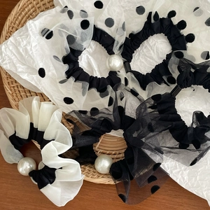 Polka dot mesh scrunchies set with large pearls on woven tray background