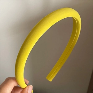 Close-up of vibrant yellow twill fabric texture on a wide padded headband fashion accessory