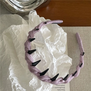 Dettaglio del cerchietto in tessuto lilla con dentini antiscivolo e trama scintillante fine