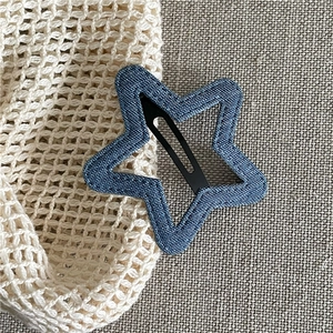 Close-up of star-shaped denim hair clip showing texture and metal snap detail