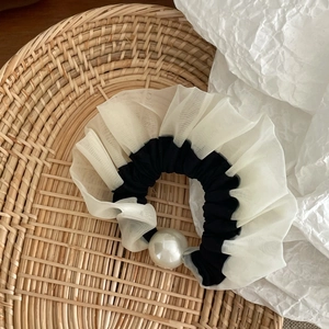 Detail of elegant mesh polka dot scrunchie with large faux pearl accent for hair