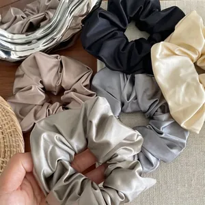 Luxurious satin silk scrunchie set in assorted neutral colors with a glossy finish