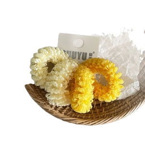 Mesh ruffled hair scrunchies in cream and yellow displayed on a white product card
