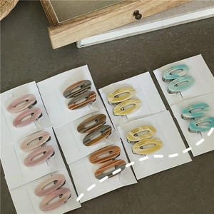 Vue détaillée de barrettes ovales en acétate texturé marbre sur cartes de présentation