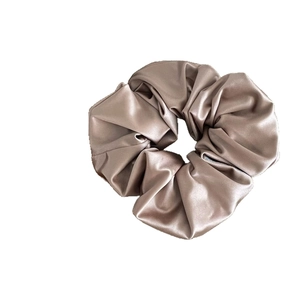 Elegant champagne satin scrunchie with silky luster for stylish ponytail hair styling
