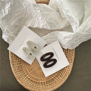 Détail de barrettes en acétate marbré avec inscription dorée sur carte cadeau