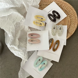 Détail de barrettes géométriques en acétate marbré de diverses couleurs sur support