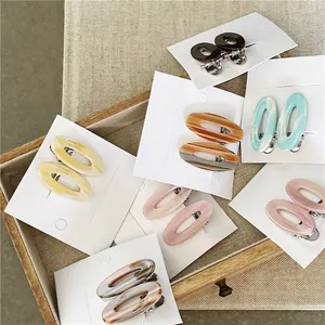 Barrettes à cheveux ovales en acétate aux textures marbrées sur plateau en bois