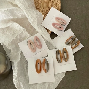 Détail de barrettes en acétate effet marbre sur un support de présentation élégant