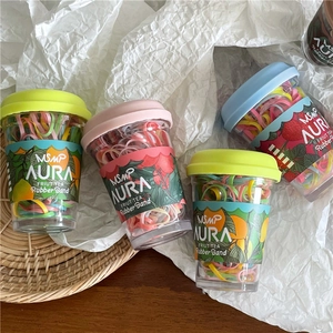 Macro view of colorful elastic hair bands packed in creative fruit tea cup containers