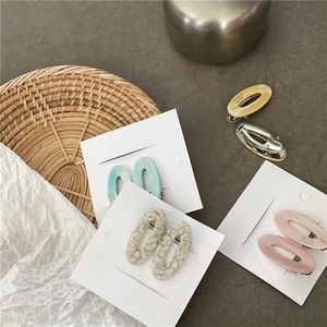 Vue détaillée des barrettes ovales en acétate aux motifs marbrés et tons pastel